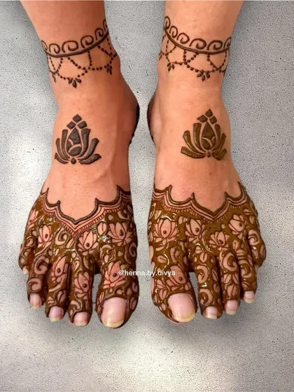 A simple and pretty design for the feet. It features a lotus motif on the top of the foot and a delicate floral pattern on the toes, with a simple chain anklet.