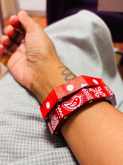 A customer styling our red Maati bangles. The geometric and paisley patterns are inspired by traditional Indian motifs, hand-painted for a rustic look.