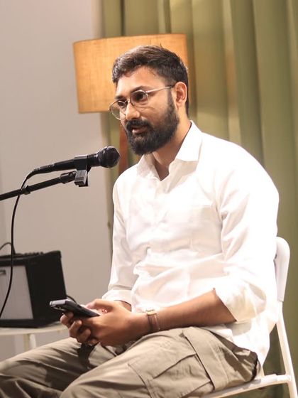 A poet shares his work in a moment of quiet reflection on stage.