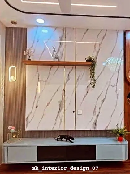 This TV unit features a hidden storage cabinet behind a marble-finish facade. The design combines wood paneling, a sleek console, and unique wall sconces for a curated look.