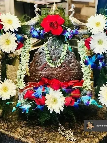 A simple yet beautiful jhula decoration for a home Janmashtami pooja. I used a combination of fresh white daisies, red roses, and blue orchids to adorn this silver swing for Bal Gopal.