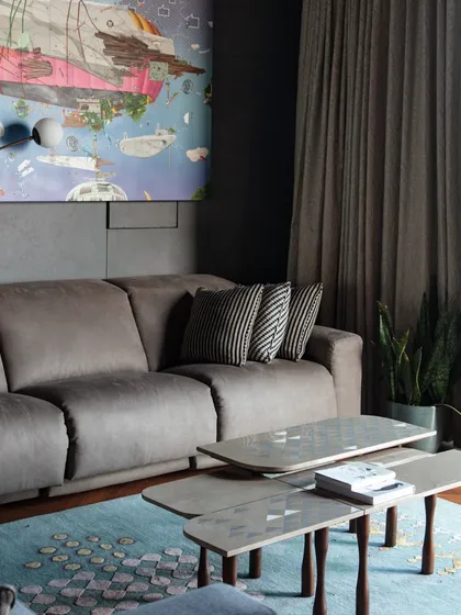 A comfortable seating arrangement in the family lounge, with a custom sofa and a tiered coffee table. The room is designed for relaxation, with a soft color palette and rich textures.