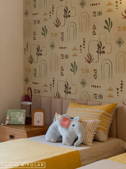 This bedroom in our Jaipur project uses a playful, hand-drawn wallpaper with abstract shapes and botanicals. The color palette is earthy and warm, creating a cozy and imaginative space for a child.