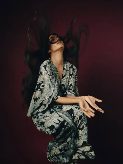 Capturing movement is one of my specialties. For this shot, I worked with the model to create this dynamic hair toss against a rich, solid background. The studio strobes freeze the motion perfectly, showcasing the hair's volume and flow for a powerful editorial statement.