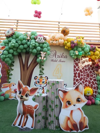 A closer look at the details of our woodland safari theme. We use high-quality cutouts of adorable animals like foxes, deer, and tigers, along with tree-stump pedestals and a giraffe-print backdrop to create a rich, layered look.