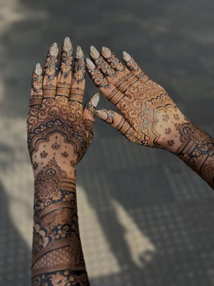 The sunlight catching the details of this beautiful custom henna art, showing the contrast and fine lines.