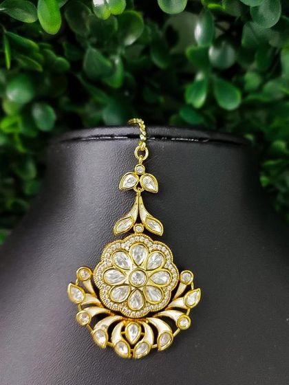 A beautiful floral-shaped maang tikka with intricate kundan and enamel work.