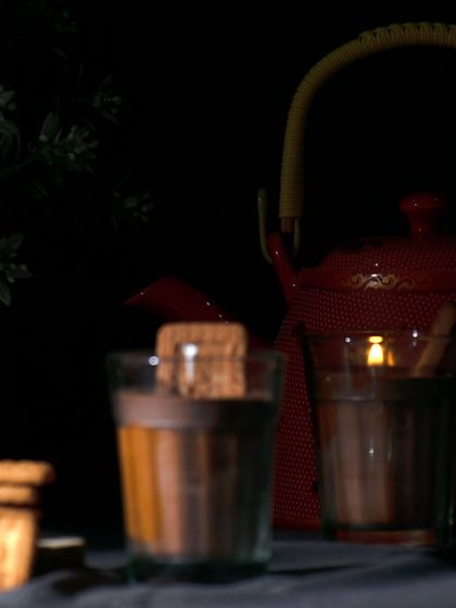 My 'Cutting Chai' candle, also known as the chai biscuit candle, glowing in the dark. It's designed to create a cozy, nostalgic mood, reminiscent of evening tea time.