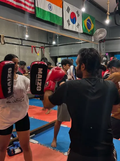 A student practices her punches with me during a busy group class. I make sure everyone gets personal attention to correct their form and improve their technique.