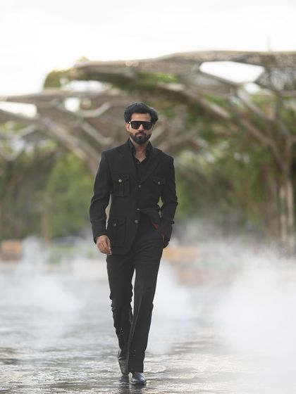 A powerful walking shot in the black Viaggio Blazer, with a misty backdrop adding to the drama.