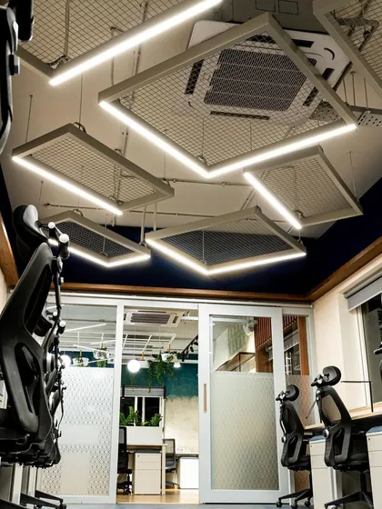 For this section of the office, I designed a unique ceiling installation using illuminated frames with mesh inserts. This industrial-chic design provides excellent task lighting for the desks below while adding a strong visual identity to the space.