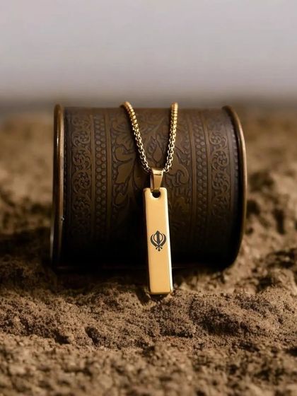 This gold bar pendant is engraved with a Khanda symbol, showing my ability to customize pieces with meaningful religious or cultural symbols.