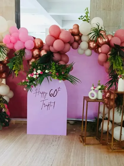 Celebrating a 60th birthday calls for elegance. For this event, I designed a sophisticated photo booth with a soft lilac arch panel, framed by a lush balloon garland in shades of dusty rose, pink, and white, accented with fresh greenery for a touch of natural beauty.