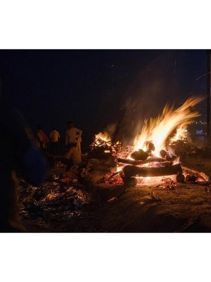 Funeral pyres burn brightly at Manikarnika Ghat during the night, a powerful and humbling sight.