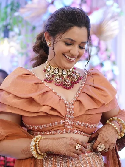 A happy, candid shot of the groom's sister, her makeup looking flawless and radiant.