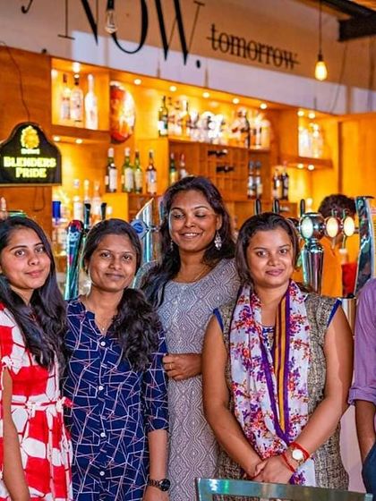 Guests posing by the bar. A great DJ set brings everyone together and creates a lively, social atmosphere.