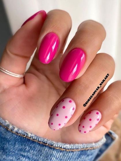 A fun yet simple design pairing a vibrant magenta with a light pink polka dot accent nail. This look is playful, chic, and perfect for adding a pop of color.