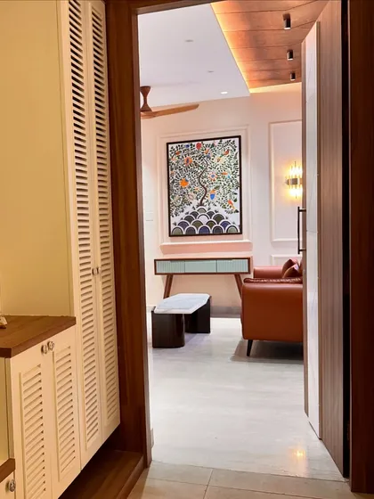A view into a living room, where a vibrant Madhubani "tree of life" painting serves as a stunning focal point.