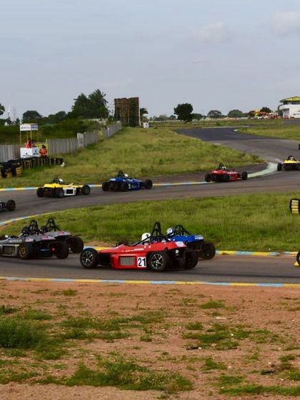 A wide view of the race, showing the strategic positioning of cars as they navigate the circuit.