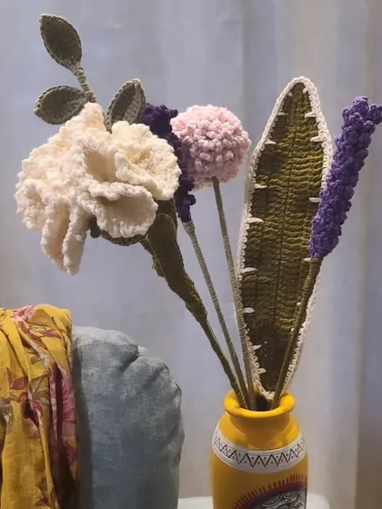 Here is one of my handmade crochet flower bouquets, perfect for adding a pop of color to your home without ever needing to water them. This arrangement features a white carnation, a pink pom-pom flower, and purple lavender, all crafted by hand and ready to brighten your space.