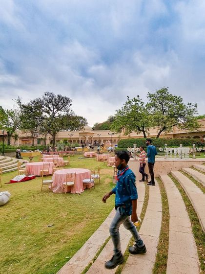 Here is another behind-the-scenes shot during the setup at Udaivilas. You can see the early stages of the event layout, with tables being placed and my team working to bring the vision to life.