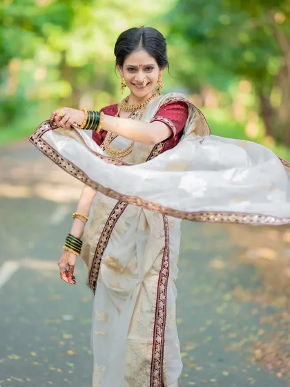 A playful moment with the nauvari drape. The makeup is designed to be light and comfortable, allowing the bride to move freely and enjoy her day.