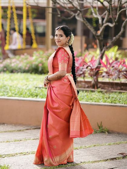 A full-length view showcasing the elegant saree drape and the traditional braided hairstyle adorned with fresh flowers, completing Ruchira's muhurtha look.