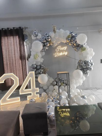 A variation of the silver and white balloon ring, this setup shows a fuller arrangement at the base. The large marquee numbers and neon sign are key elements that I can include in your custom anniversary package.