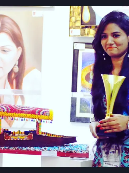 Artist Aafreen Khan proudly displays her award-winning paper quilling artwork of a 'shikara' boat. This piece, which participated in a national-level exhibition, demonstrates the artistic potential of paper craft.