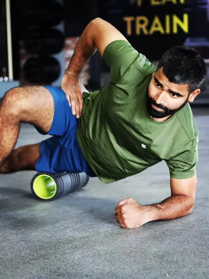 Foam rolling is a key part of our recovery protocol. Here, I'm using a foam roller on my IT band to release muscle tightness, improve flexibility, and aid in recovery after a tough leg day.