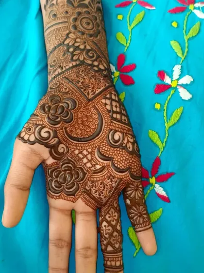 A progress shot of a semi bridal henna design. This shows the back of the hand and wrist, with a beautiful floral cuff.