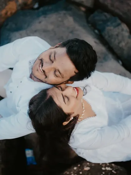 An aerial view of a couple lying on the rocks, creating a unique and intimate pre-wedding portrait.