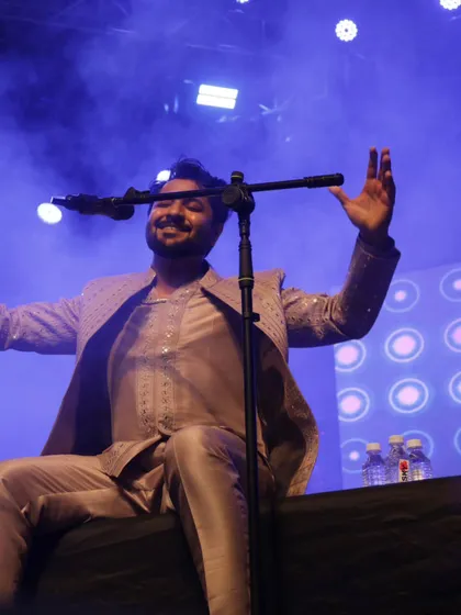 A relaxed moment on stage, smiling at the crowd's energy.