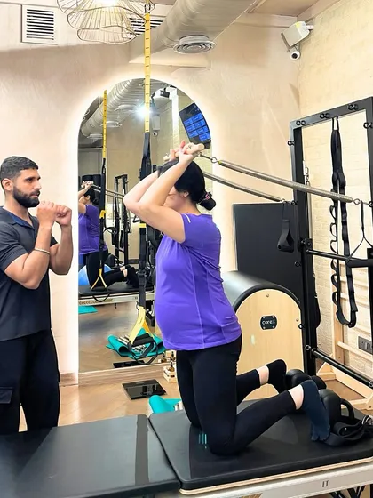Our prenatal sessions focus on safe and effective movements. Here, an expecting mother works on her posture and arm strength with the guidance of our knowledgeable instructor.