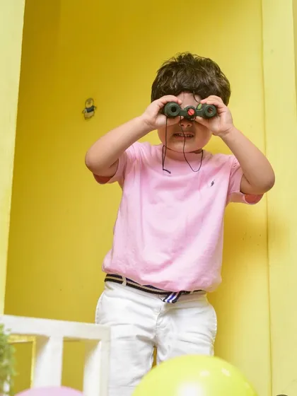 An adventurer on the lookout with his binoculars, exploring every corner of the play area.