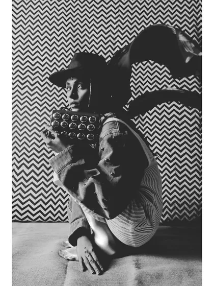 An abstract, high-contrast black and white shot from 'Neo-Boheme'. The styling incorporates geometric patterns in both the background and the accessories, creating a visually complex image.