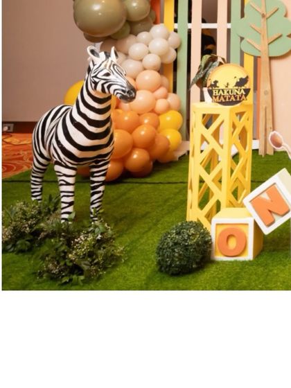 A close-up of our 'Hakuna Matata' setup, featuring a life-sized zebra prop, 'ONE' letter blocks, and a 'Hakuna Matata' sign, all contributing to the fun Lion King theme.