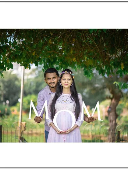 The parents-to-be hold up letters spelling "MOM", a sweet and creative announcement.