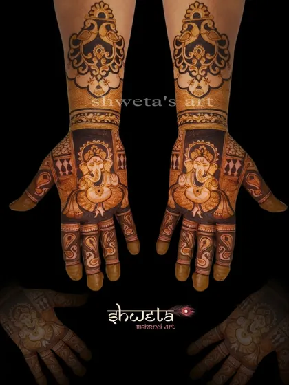 A symmetrical design featuring Lord Ganesha on both palms. The bold outlines and detailed shading make the deity the centerpiece of this auspicious mehendi.