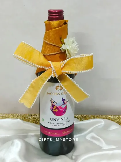 A beautifully wrapped bottle of non-alcoholic wine, adding a celebratory touch to the wedding hamper.
