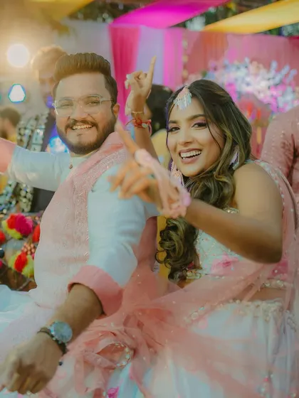 The Haldi couple dancing, her hair styled for movement and fun.