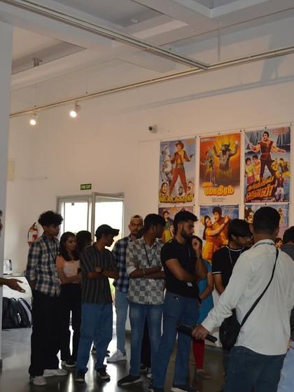 The student group listening to a guide explain the significance of the collected cinema memorabilia.