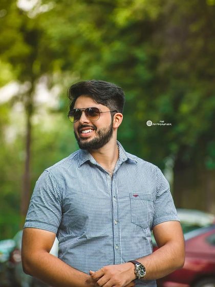 A bright, friendly outdoor portrait. The genuine smile and natural lighting create a very approachable and positive image.