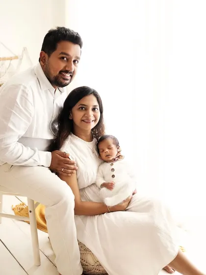 A beautiful, relaxed family portrait. Everyone is looking at the camera, a perfect first official photo for this new family.