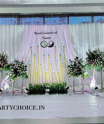 A beautiful stage setup for a Roce Ceremony. The decor uses a soft pink and white color palette with elegant lighting and floral arrangements.