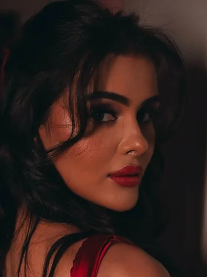A classic over-the-shoulder pose that highlights the sharp winged liner and the bold lip color.