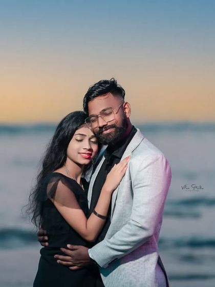 A close and intimate embrace with the ocean waves in the background. The soft light of dusk creates a romantic and peaceful mood.