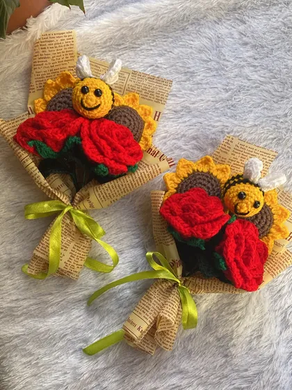 A pair of cheerful mini-bouquets. Each one features a bright red rose, a sunflower, and a happy little bee, making it a perfect small gift to brighten someone's day.