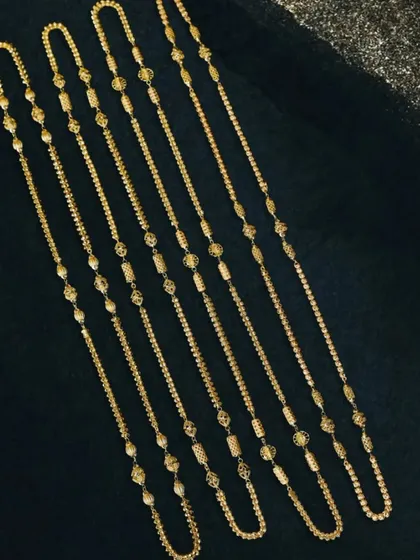 When you have a collection to showcase, I create compelling flat lay arrangements. Here, I've laid out multiple gold chains on a dark, textured surface to highlight the variety in design and length for a catalog spread.