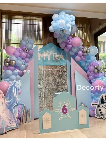 A different angle of the Frozen party setup, highlighting the beautiful balloon garland in shades of blue, purple, and pink.